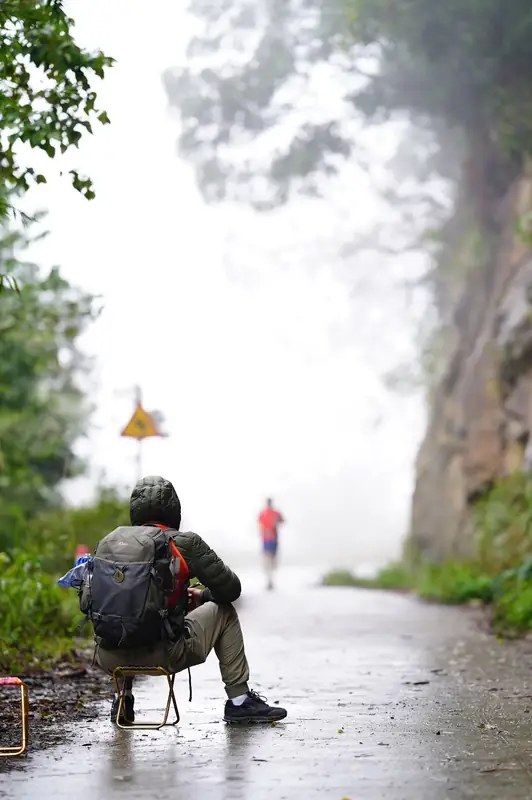 Waiting for runners on a misty trail