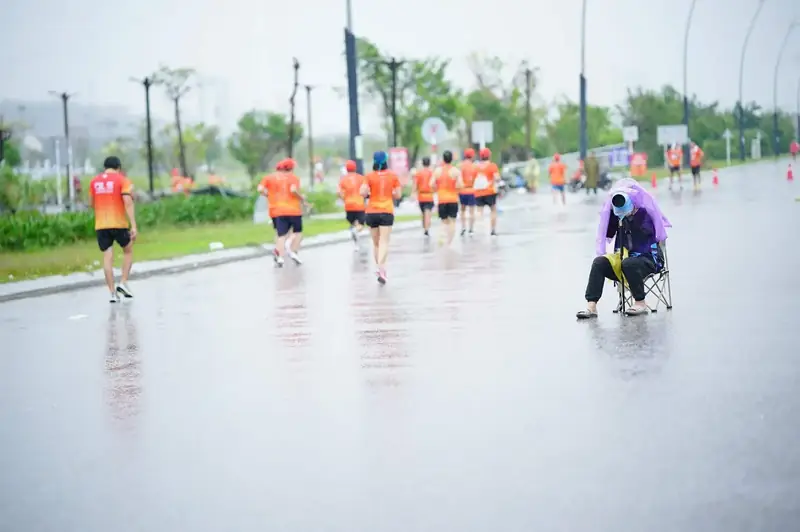 Waiting patiently for runners in the rain